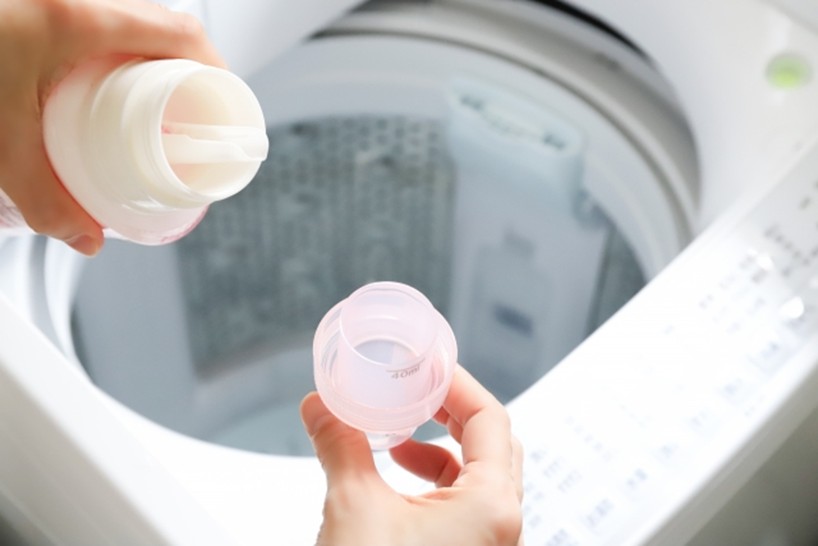 洗濯機に柔軟剤を入れようとしている写真