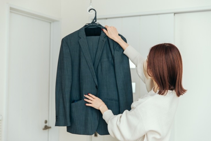 スーツをハンガーにかける女性