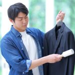 スーツをブラッシングする男性